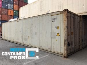 Left Angle Cargo Doors  40' High Cube Refrigerated Shipping Container in front of Shipping Containers Stacked at Intermodal Depot - Reefer Container Pros: Buy & Rent Refrigerated Shipping Containers